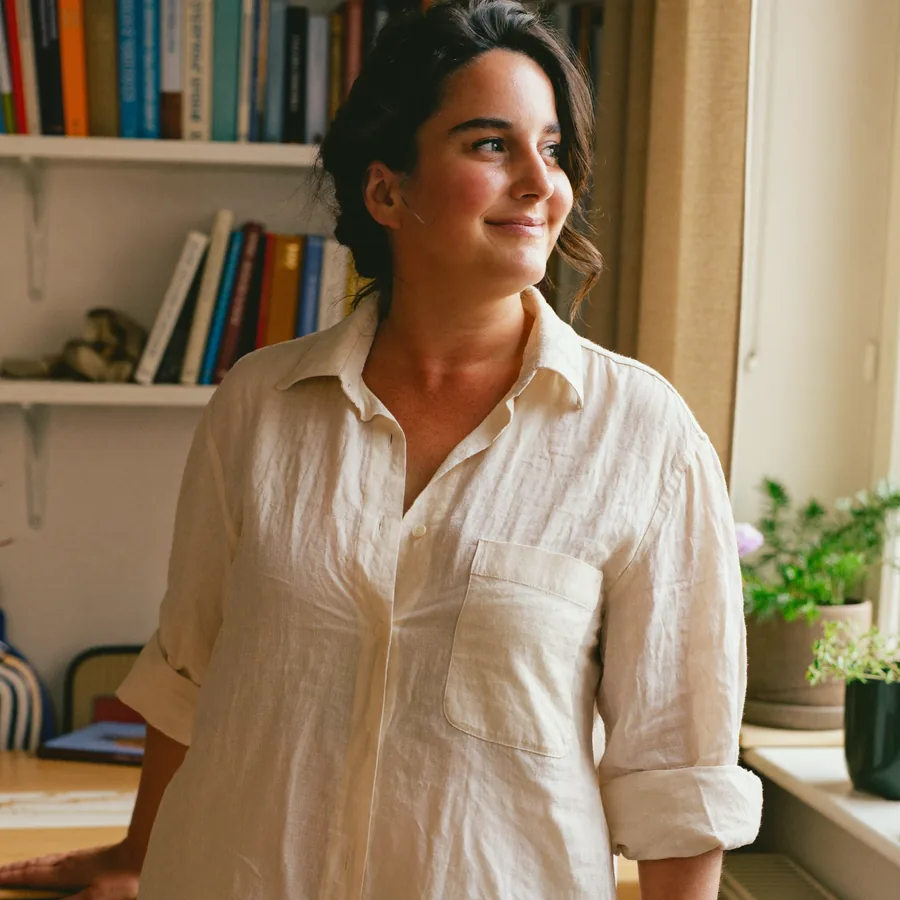 Mujer sonriente en casa, junto a la ventana